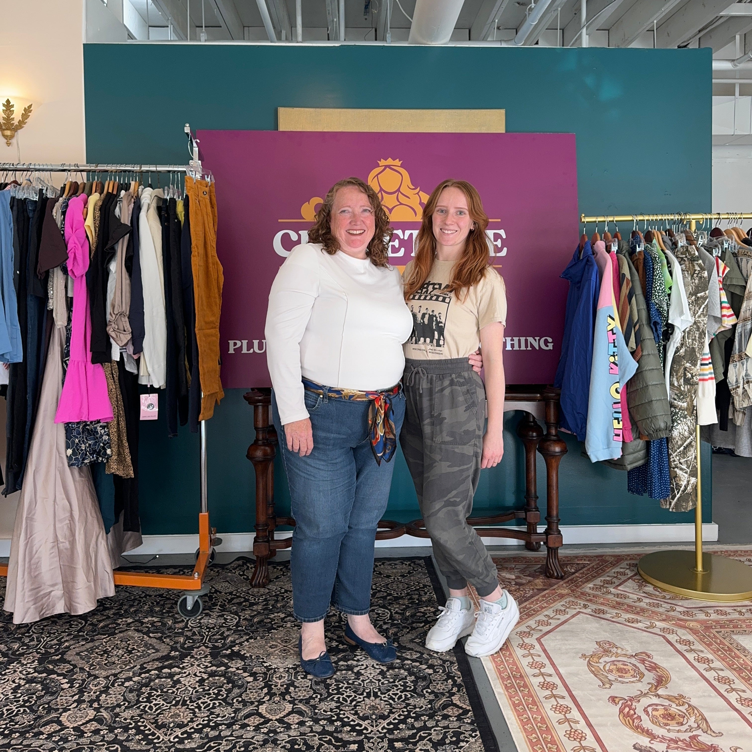 Two people standing on a staircase with a purple poster in the background